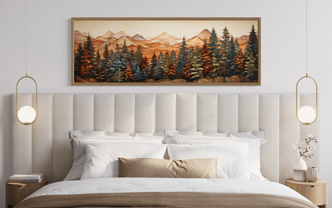 Long horizontal canvas wall art of a rustic forest and mountains above a bed in a modern room.
