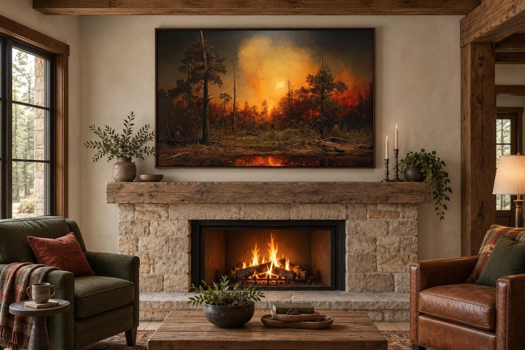 Framed canvas wall art of a forest wildfire hanging above a stone fireplace in a rustic living room.