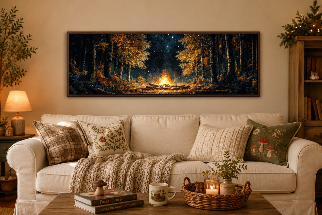 Panoramic forest campfire wall art hanging above a cozy cream sofa in a rustic living room.