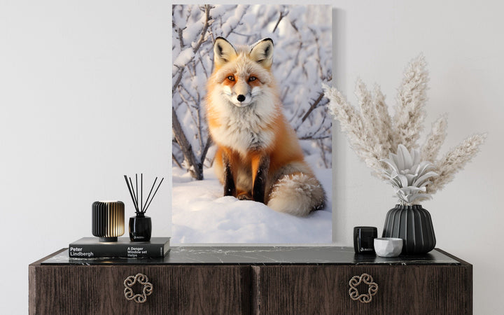 Fox in snow photography style canvas wall art displayed above a dark wood sideboard.