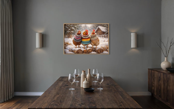 Framed wall art of three chickens in colorful sweaters standing in a snowy winter landscape.