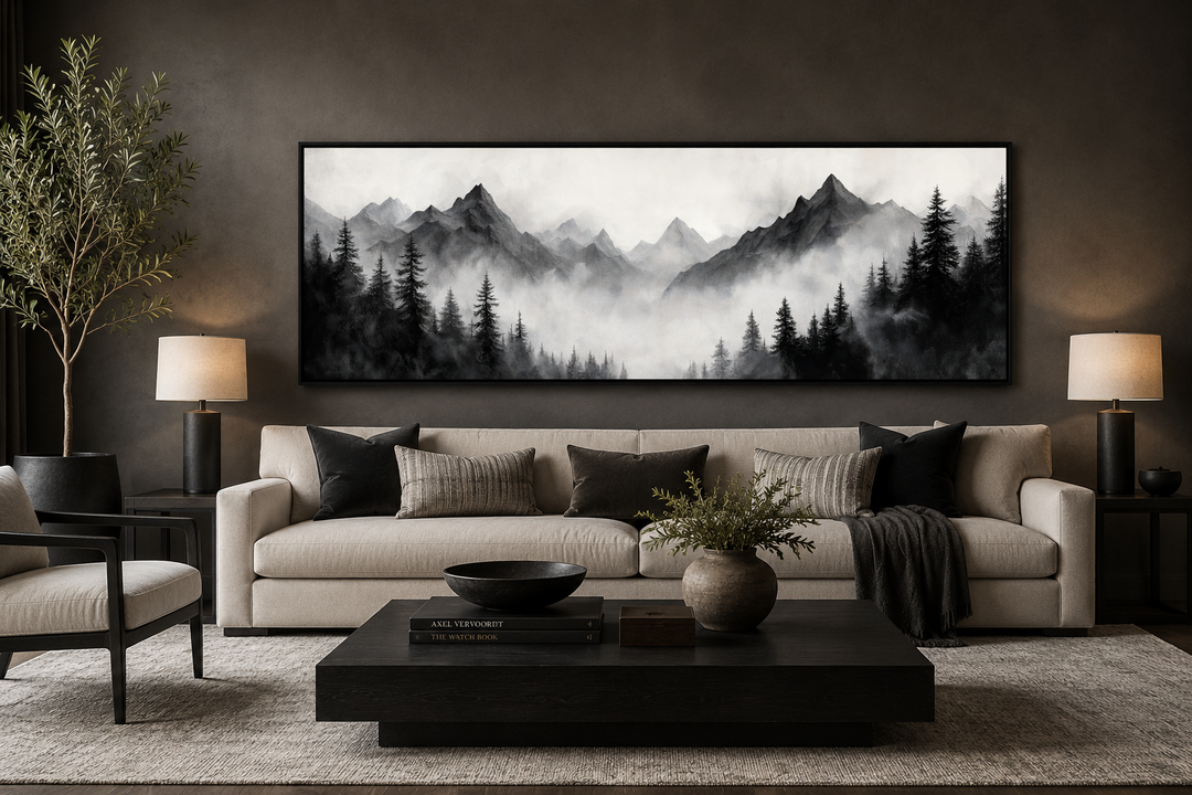 Black and white watercolor foggy mountain forest long horizontal wall art above a beige sofa.