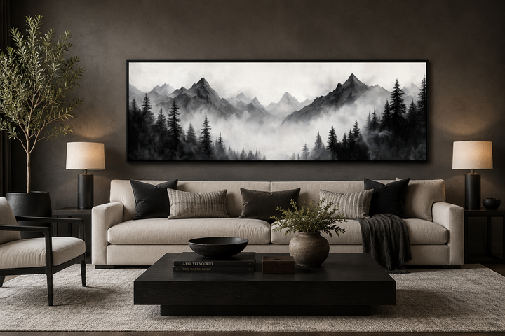 Black and white watercolor foggy mountain forest long horizontal wall art above a beige sofa.