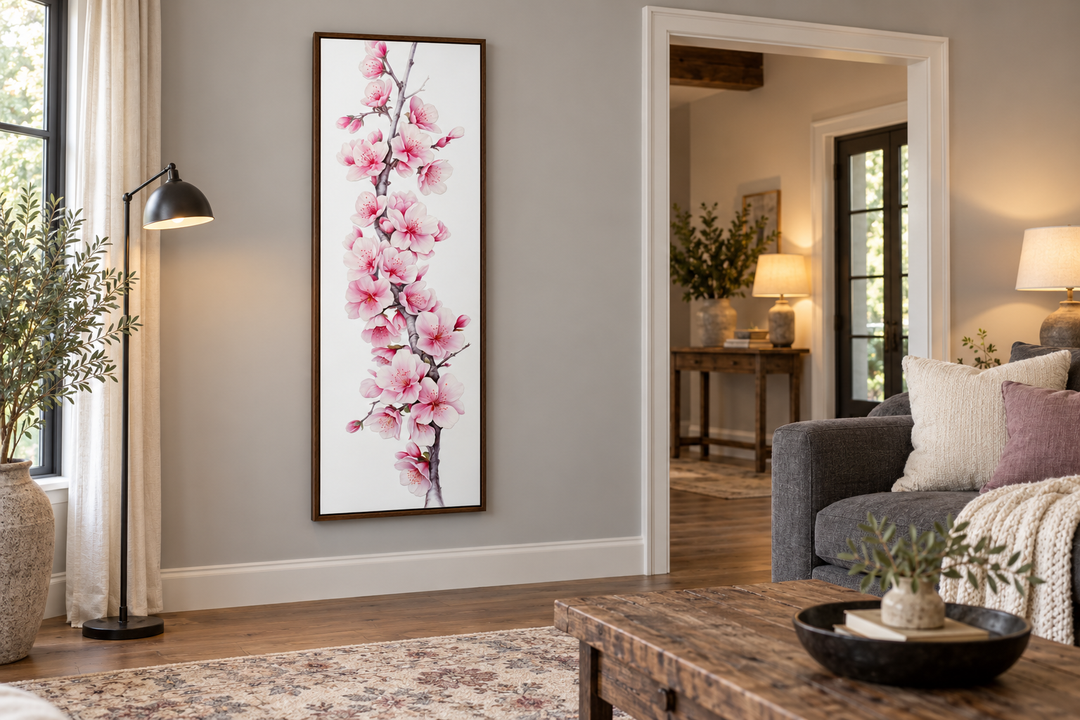 Vertical framed canvas wall art featuring pink watercolor cherry blossoms in a modern living room.