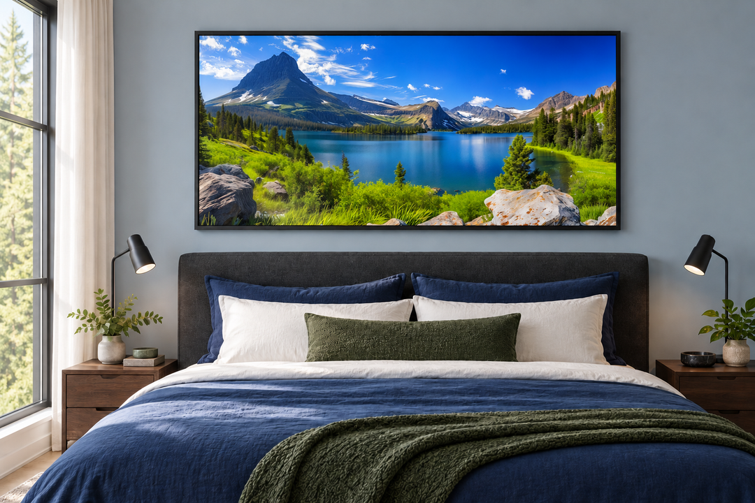 Framed canvas print of Glacier National Park's alpine lake and mountains above a modern bed.