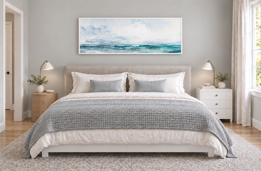 Minimalist ocean blue and gray horizontal framed canvas wall art hanging over a bed in a bedroom.