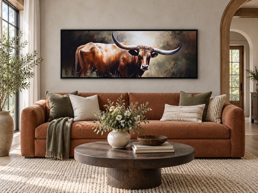 Panoramic framed canvas wall art of a Texas Longhorn steer hanging above a brown sofa.