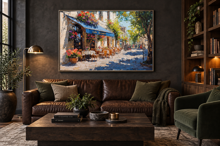 Paris Street Cafe framed canvas wall art hanging above a brown leather sofa in a dark living room.