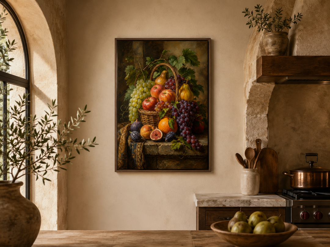 Framed still life painting of a fruit basket on a kitchen wall above a marble countertop.