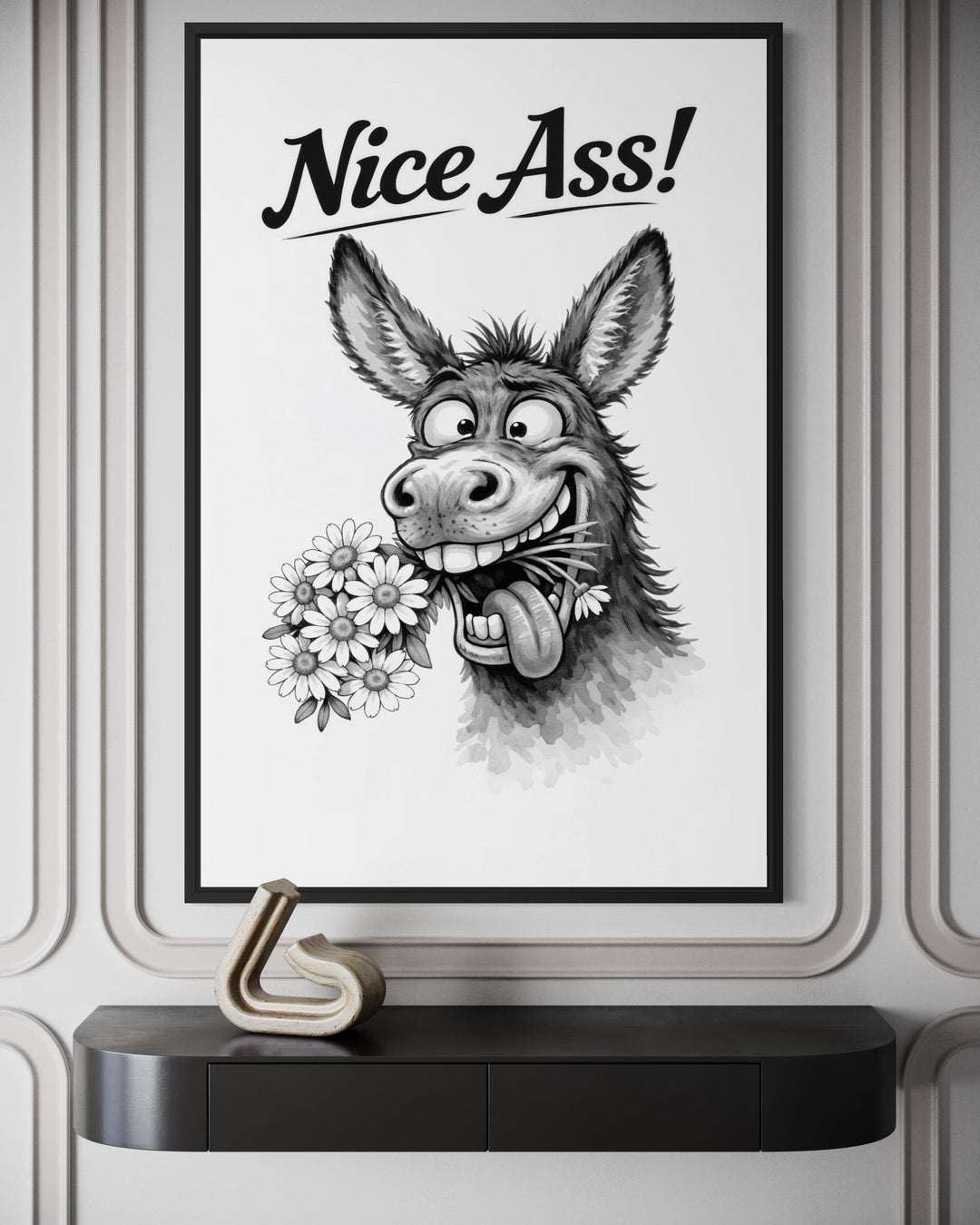 A black and white canvas print of a cartoon donkey with flowers and the text Nice Ass! framed on a wall.
