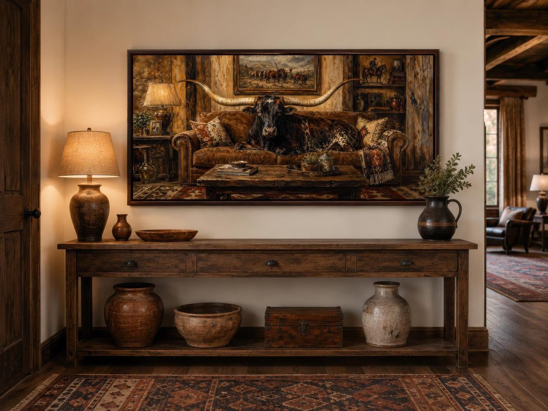 Framed canvas print of a Texas Longhorn bull lounging on a leather couch in a rustic ranch interior.