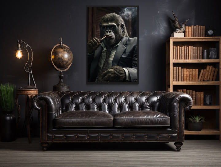 Framed canvas wall art of a gorilla in a suit smoking a cigar, hung above a leather sofa.