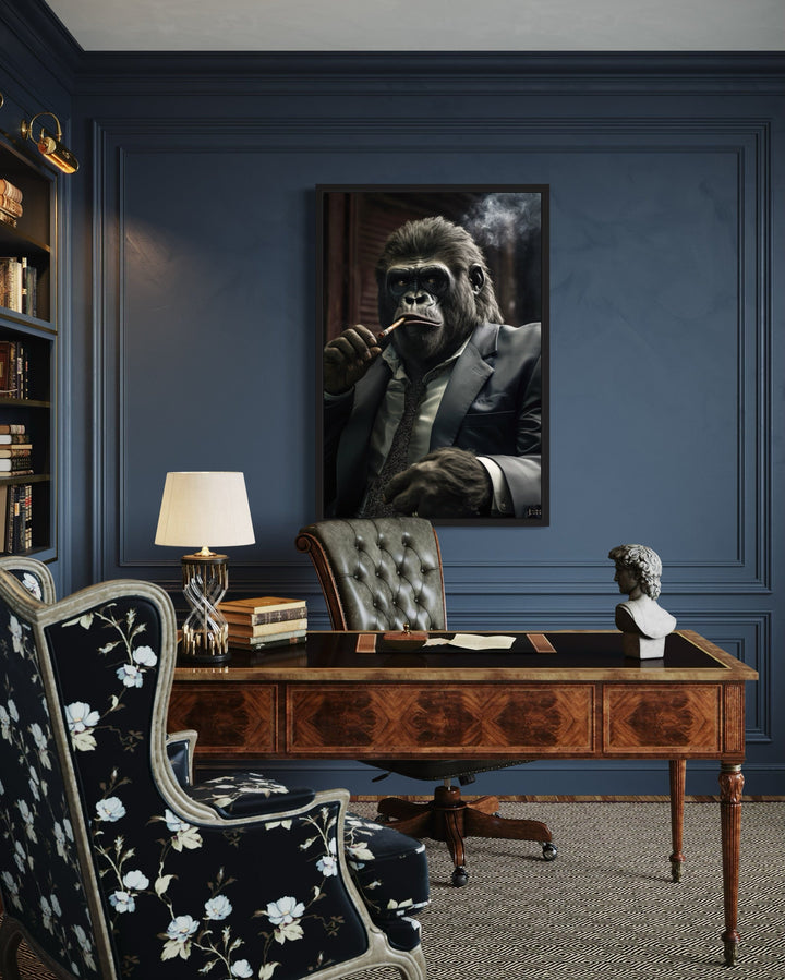 Framed canvas wall art of a gorilla in a suit smoking a cigar, hanging in a dark blue office.