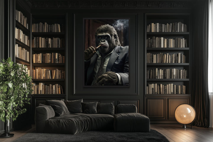 Framed canvas art of a gorilla in a suit smoking a cigar, hung in a dark library with a black sofa.