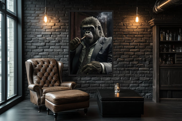 Framed canvas wall art of a gorilla in a suit smoking a cigar, hung in a dark brick office.