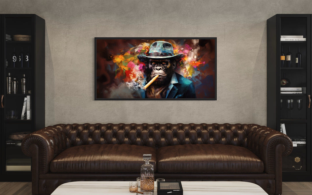 Gangster gorilla in a fedora and suit smoking a cigar canvas wall art above a brown leather sofa.