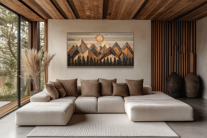 Geometric wood mountain and pine trees forest canvas wall art above a modern sofa in a living room.