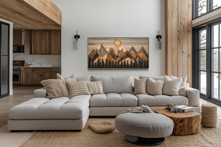 Geometric wood mountain and pine trees forest canvas wall art hanging above a modern sectional sofa.