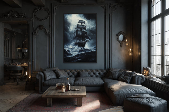 Gothic framed canvas wall art of a ghost pirate ship in a stormy ocean above a black leather sofa.