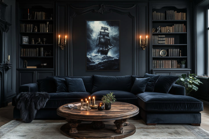 Gothic framed canvas wall art of a ghost pirate ship in a stormy ocean above a dark velvet sofa.