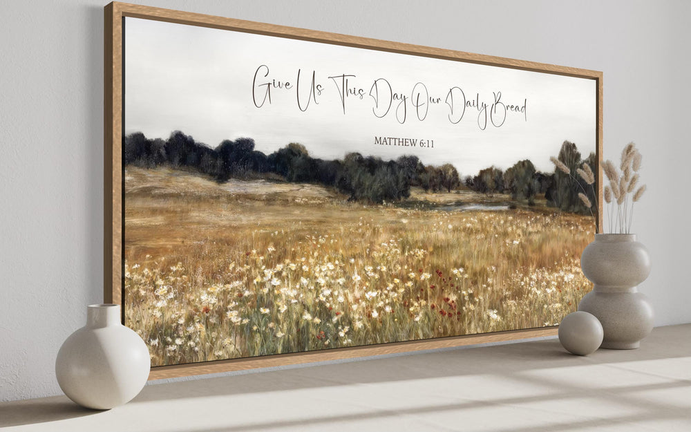 Framed landscape wall art of a wildflower field with the scripture Give Us This Day Our Daily Bread.