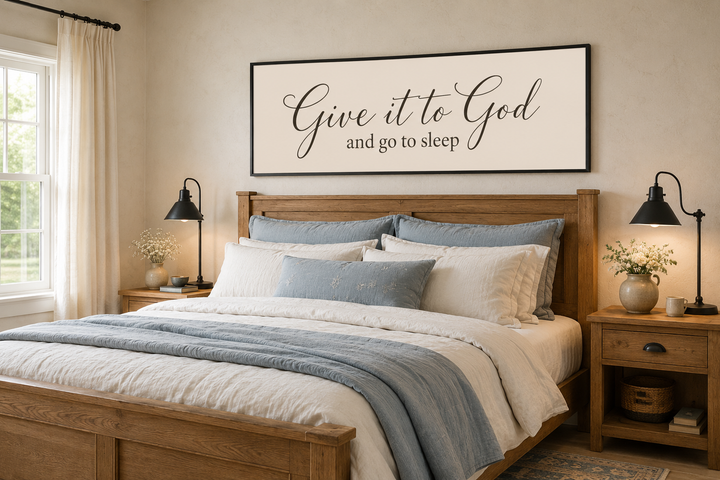 Give it to God and Go to Sleep long horizontal sign above a wooden bed in a neutral bedroom.