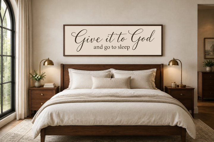 Give it to God and Go to Sleep long horizontal sign in a wooden frame above a bed.