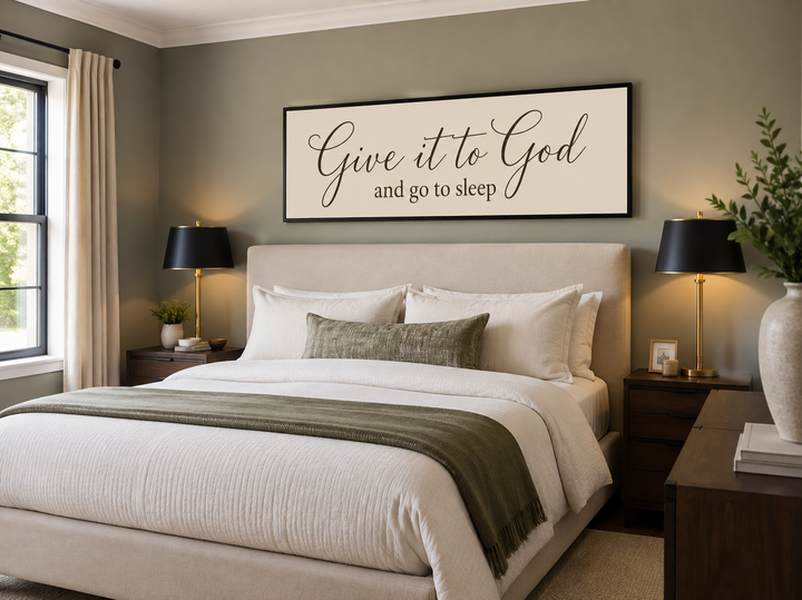 Give it to God and Go to Sleep long horizontal canvas sign hanging above a bed in a neutral bedroom.