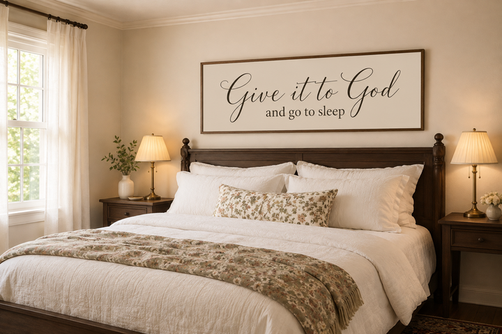 Give it to God and Go to Sleep long horizontal canvas sign hanging above a bed in a neutral bedroom.