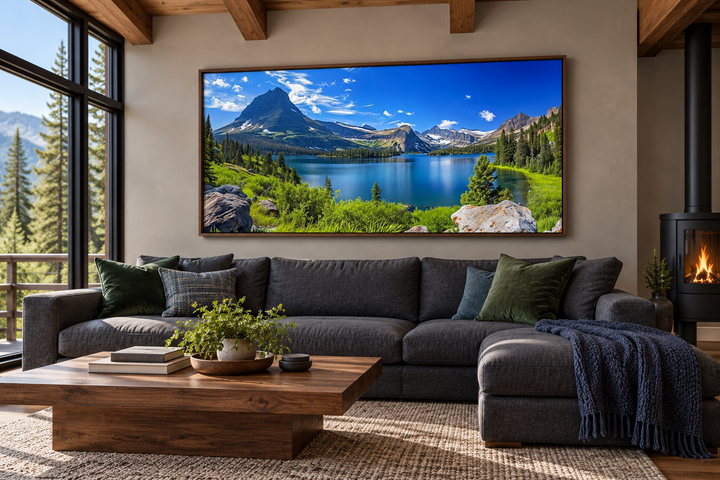 Framed canvas print of Glacier National Park landscape hanging above a sofa in a rustic living room.