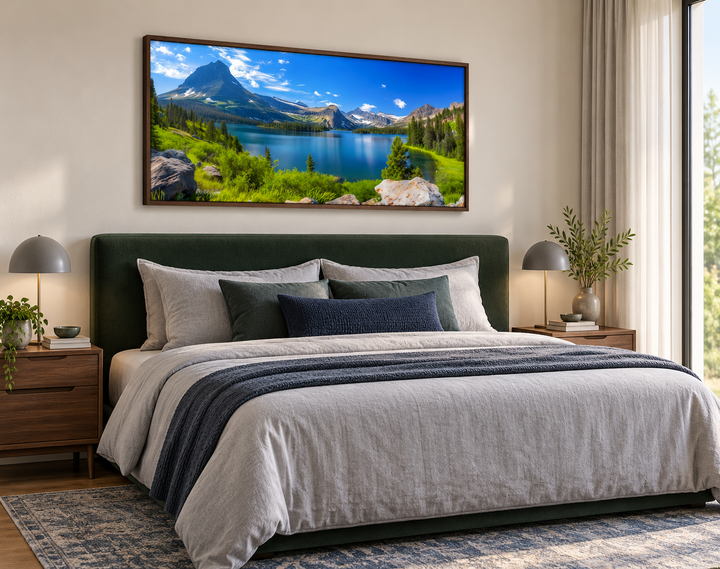 Framed canvas print of Glacier National Park landscape hanging above a bed in a modern bedroom.