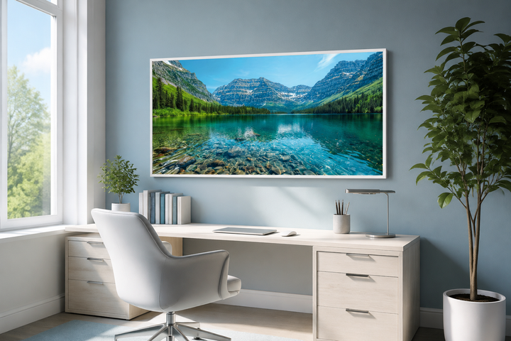 Framed canvas wall art of Glacier National Park landscape hanging above a desk in a home office.