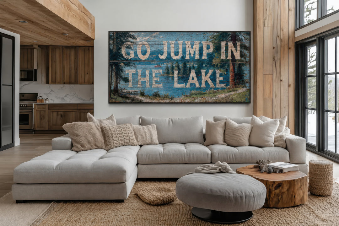 Rustic Go Jump in the Lake wood-style canvas wall art above a modern sectional sofa in a lake house.
