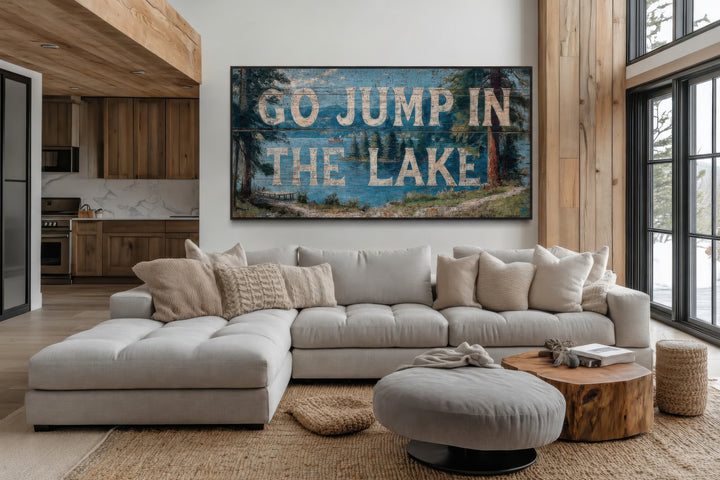 Rustic Go Jump in the Lake wood-style canvas wall art above a modern sectional sofa in a lake house.