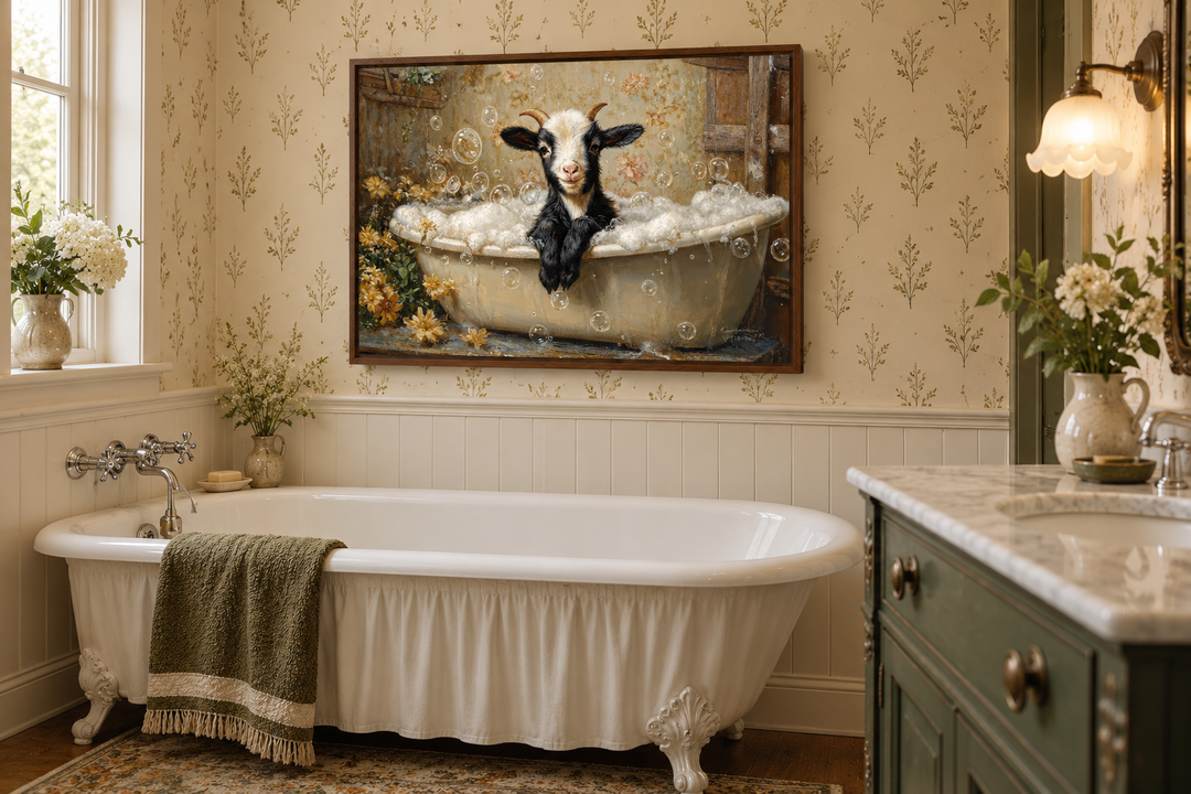 Goat in a Bathtub Framed Canvas Wall Art hanging above a vintage clawfoot tub in a bathroom.