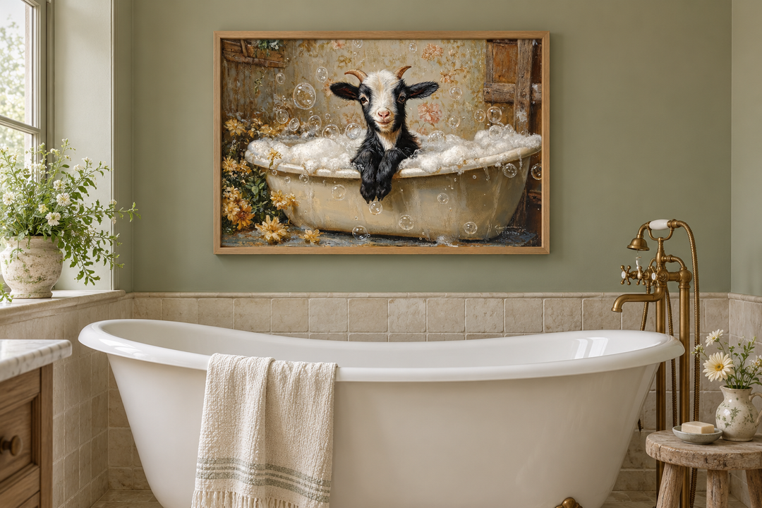 Goat in a Bathtub Framed Canvas Wall Art hanging in a sage green bathroom above a white tub.