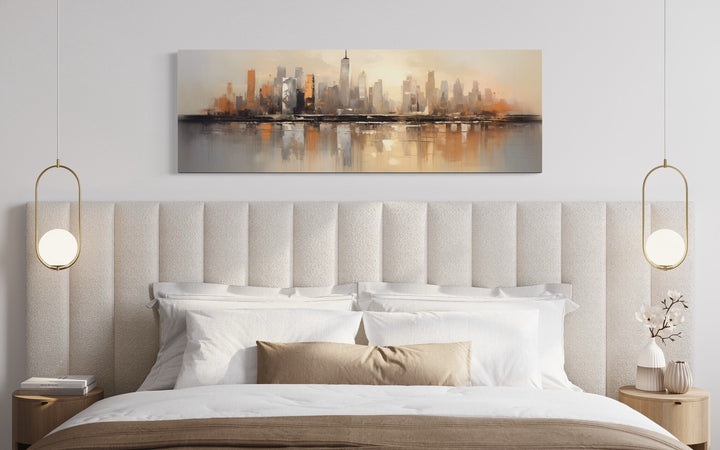 Horizontal abstract New York City skyline wall art in gold and silver tones above a modern bed.