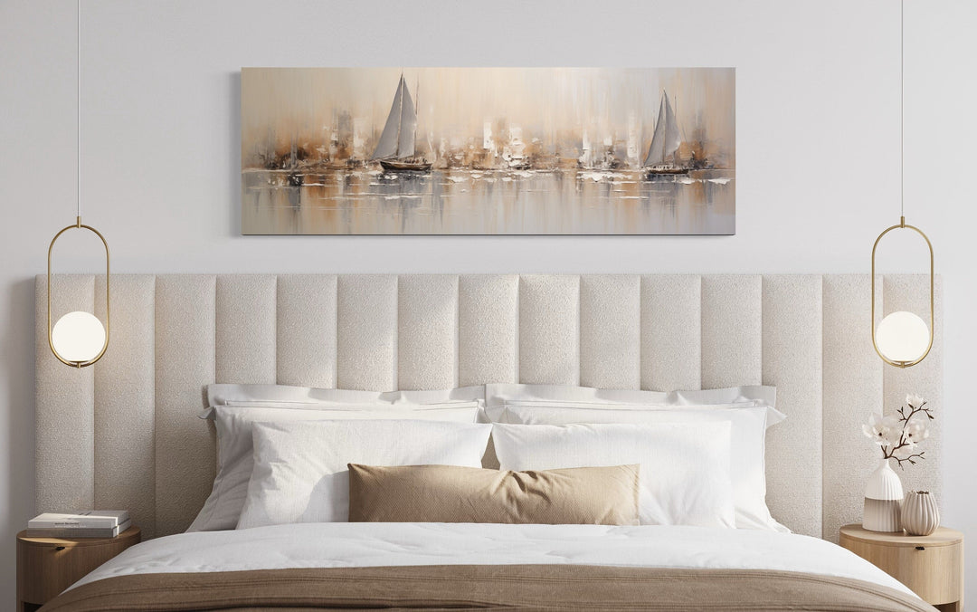 Gold and silver abstract sailboats canvas wall art hanging above a bed in a modern bedroom.