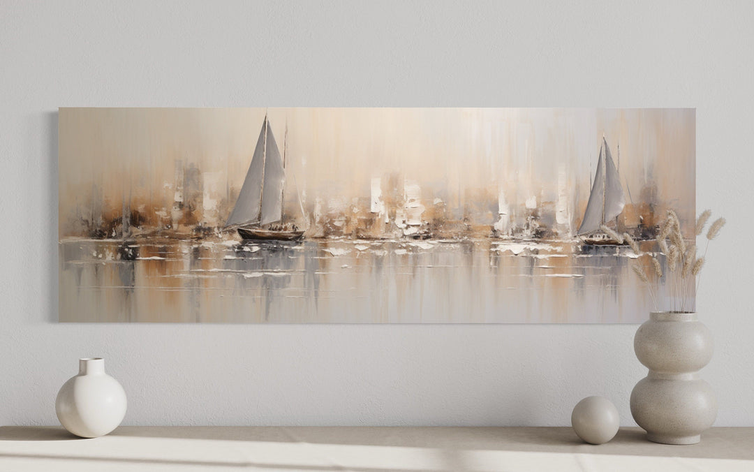 Gold and silver abstract sailboats in ocean long horizontal canvas wall art above a console table.