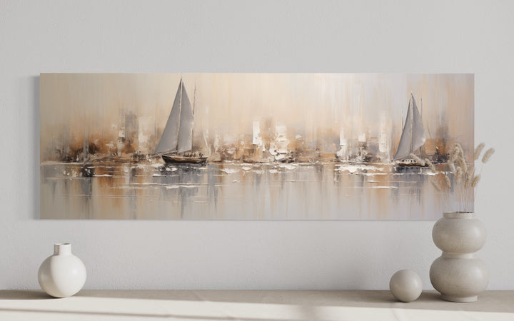 Gold and silver abstract sailboats in ocean long horizontal canvas wall art above a console table.