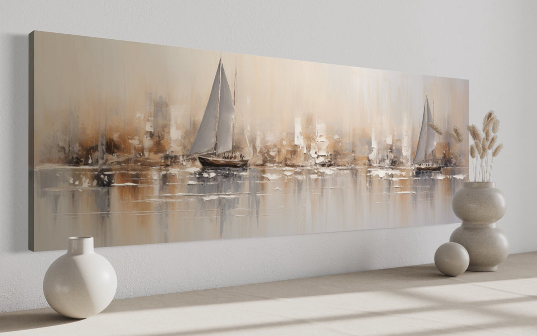 Long horizontal abstract wall art of gold and silver sailboats on a calm ocean above a floor.