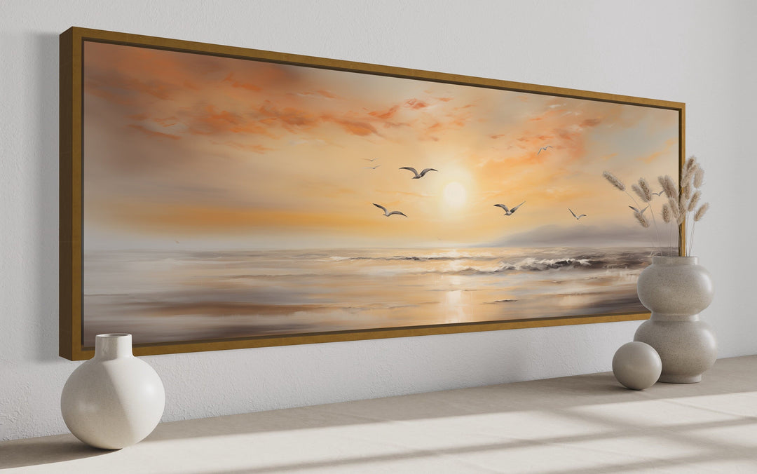 Narrow horizontal wall art of a gold and silver beach sunset seascape with birds in a gold frame.