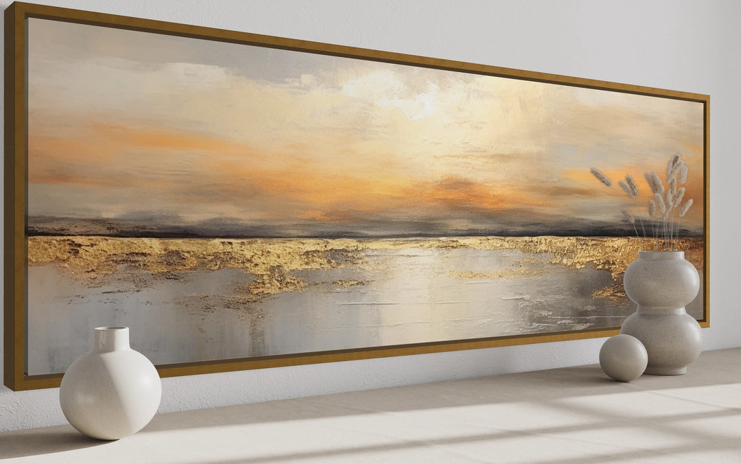 Gold and silver ocean sunset long horizontal wall art in a thin gold frame above a neutral surface.