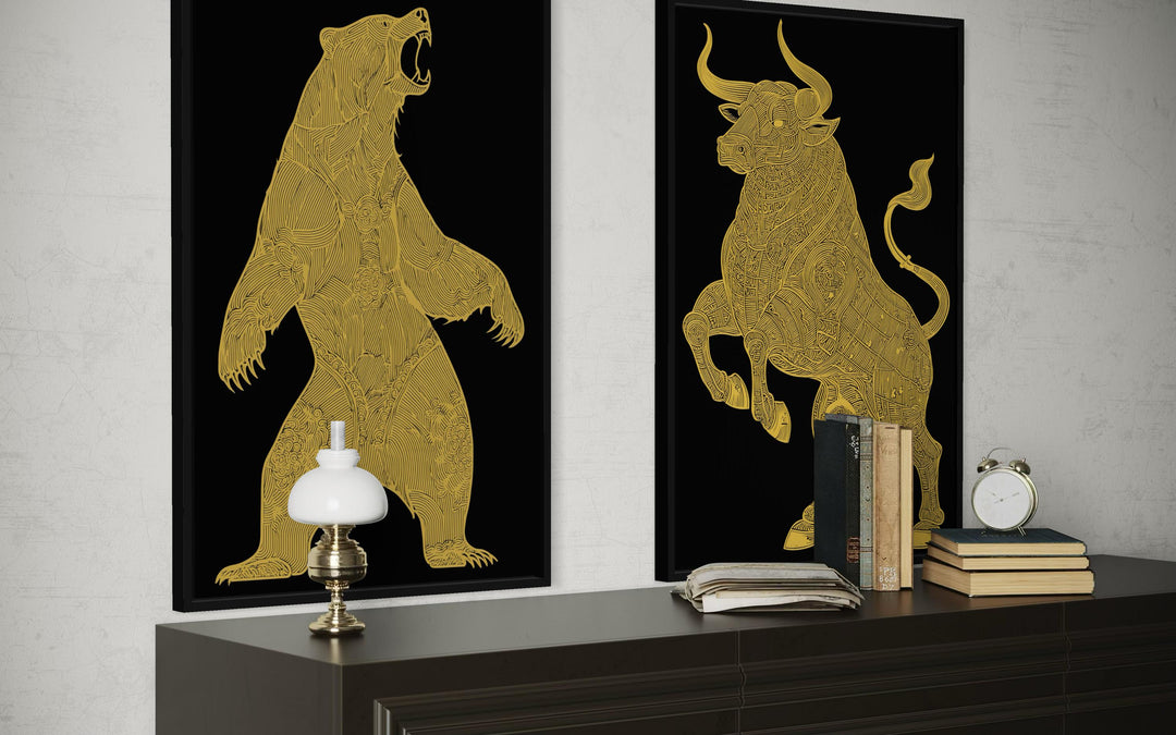 Two black and gold canvas prints of a bear and a bull displayed above a dark wood console.