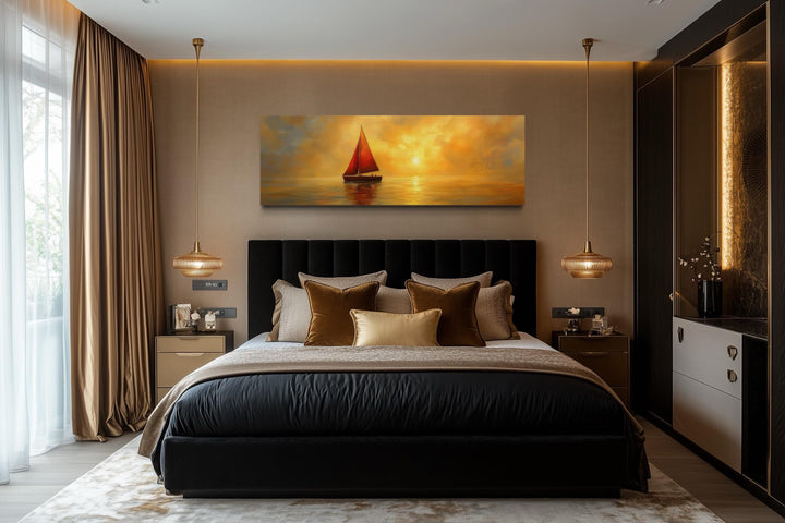 Gold and red sailboat long narrow framed canvas wall art hanging above a black bed in a bedroom.