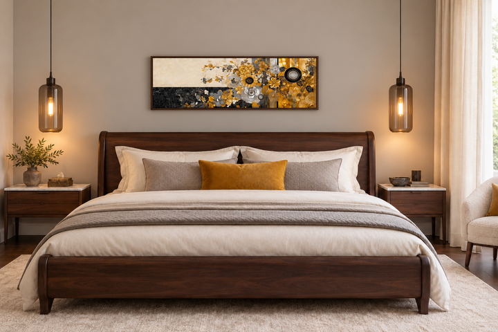 Gold, silver, and black floral abstract horizontal wall art in a walnut frame above a wooden bed.