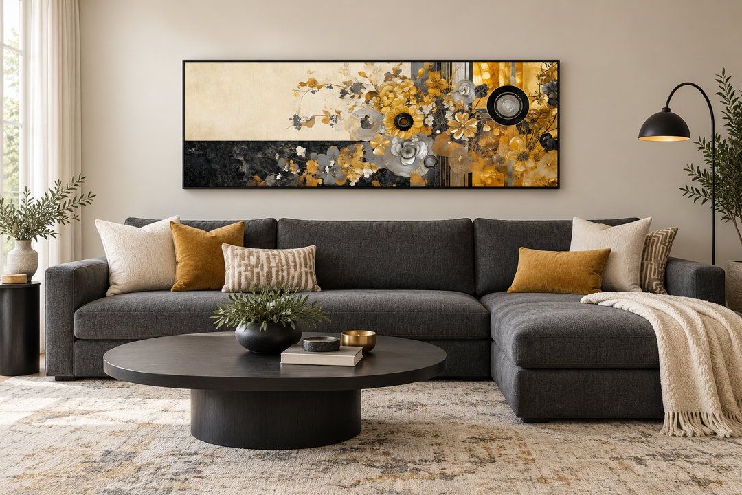 Gold, silver, and black floral abstract horizontal wall art in a black frame above a charcoal sofa.