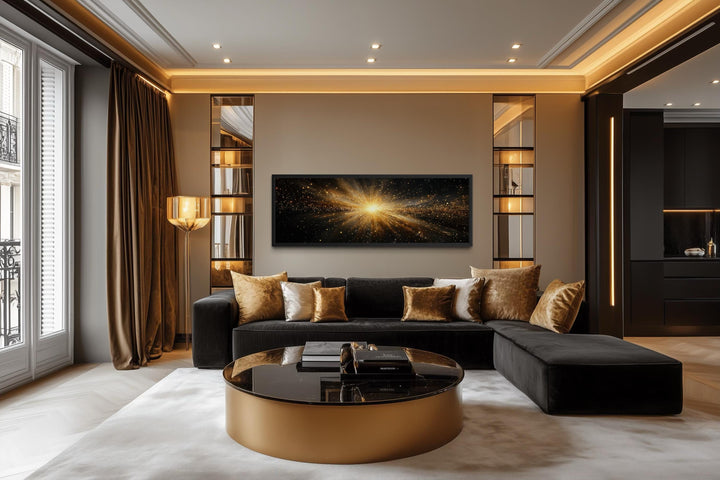 Horizontal black and gold starburst wall art displayed above a sofa in a modern living room.