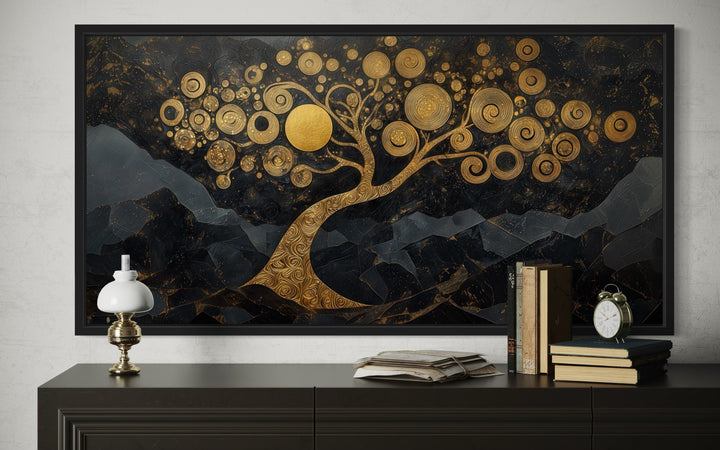 Gold Tree of Life wall art with swirling branches on a black background above a dark dresser.