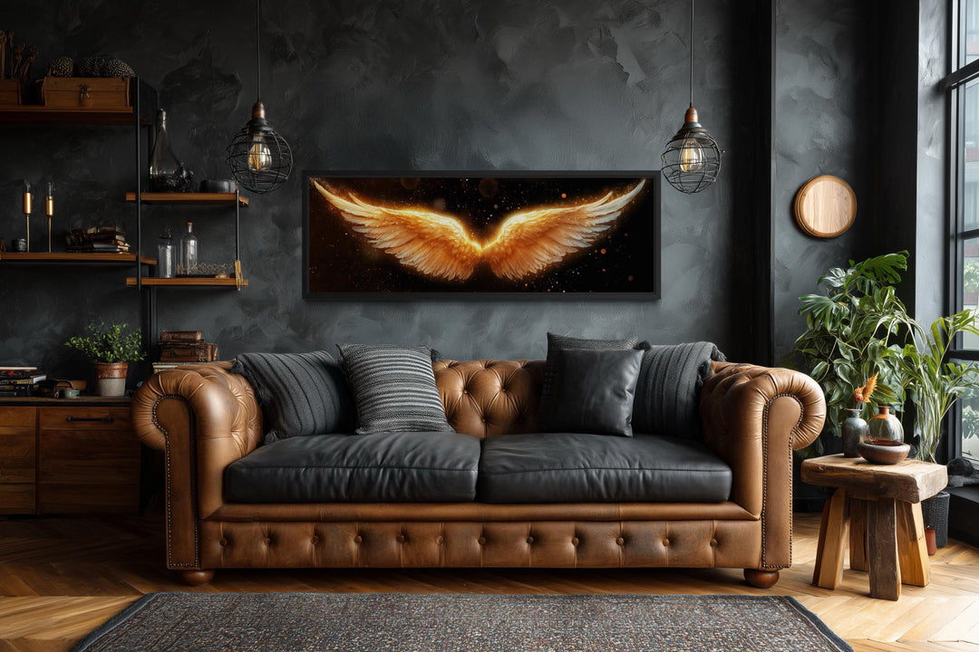 Horizontal canvas print of glowing golden angel wings on a black background in a dark modern room.